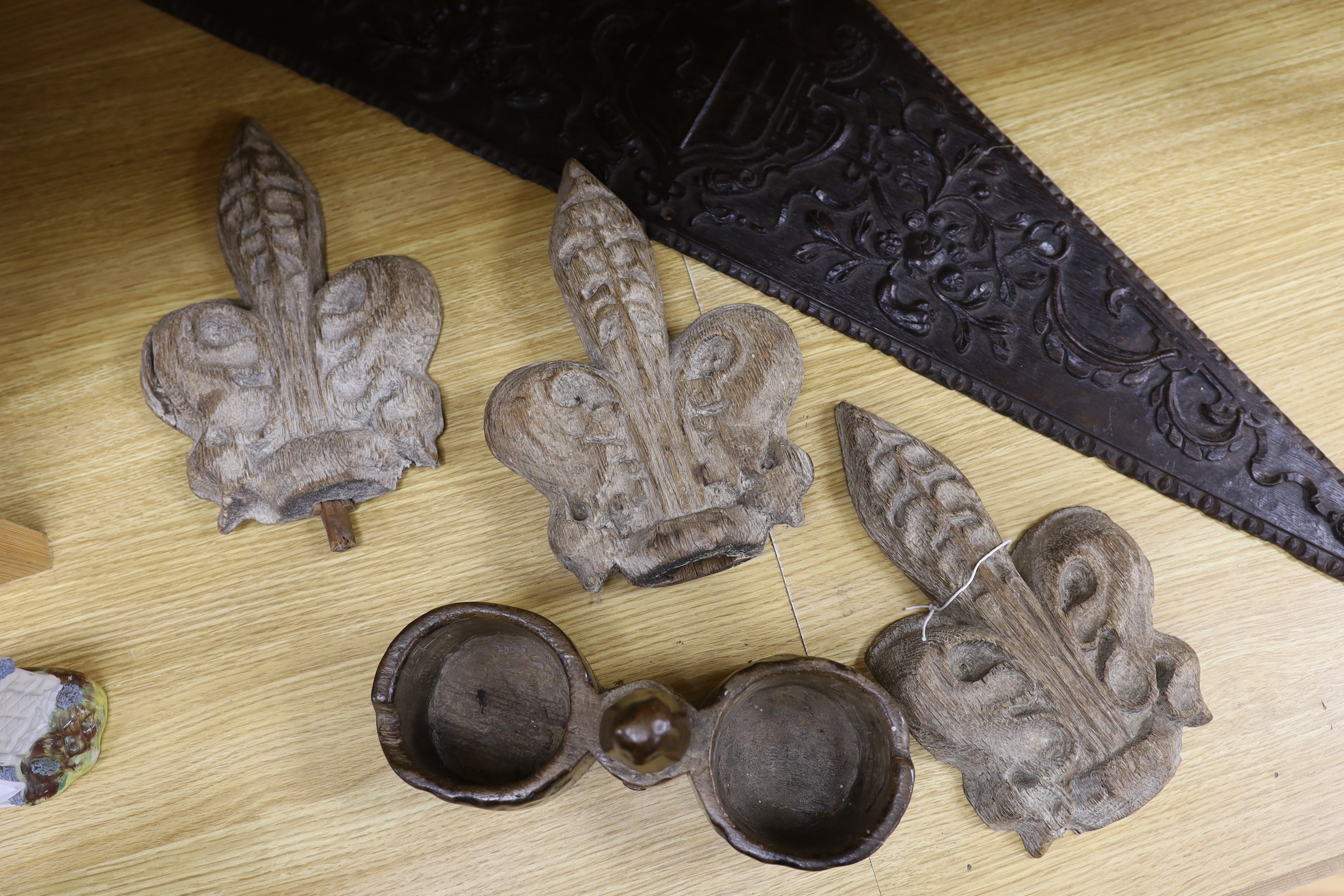 Three religious carvings; three carved Acanthus leafed pew finials, a two section carved Alms coin box and a triangular carved panel, largest 95cm long
